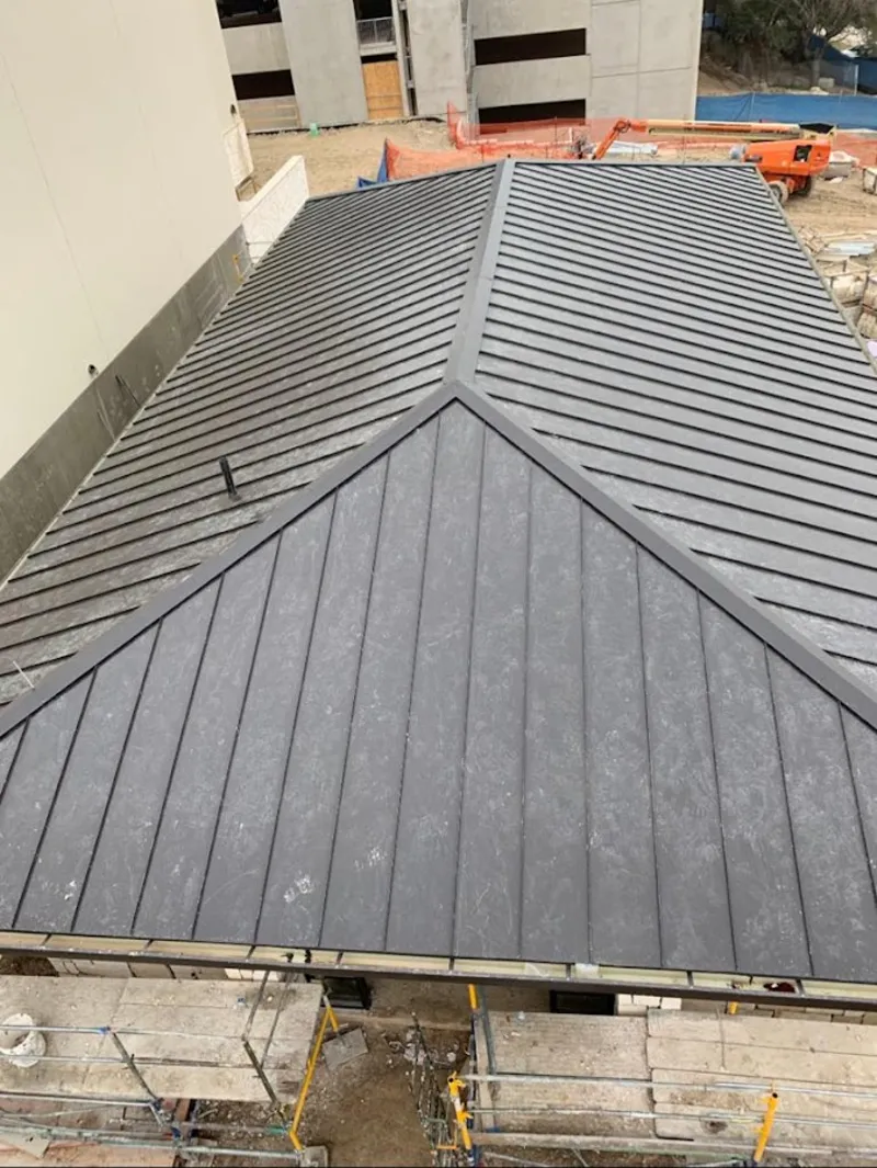 Commercial metal roof construction with crane equipment in North Tustin